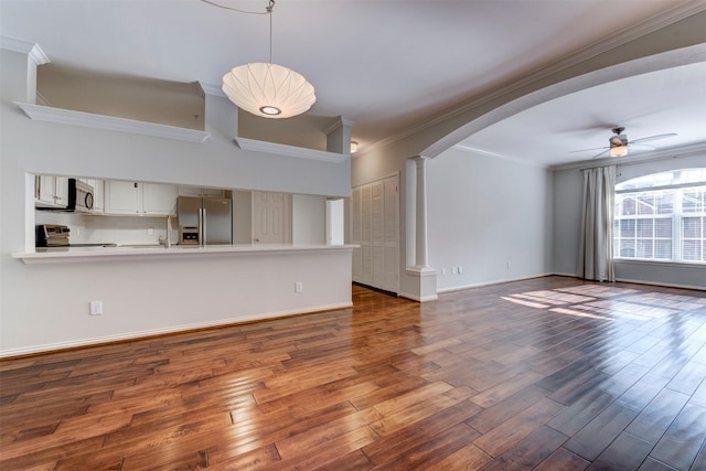 2111 Welch St Unit A107, Houston, TX 77019 - unfurnished living room featuring decorative columns, ceiling fan, crown molding, arched walkways, and dark wood-style flooring