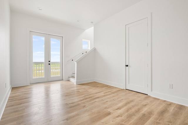 544 Annabelle, Gilchrist, TX 77617 - unfurnished living room featuring stairway, french doors, baseboards, and light wood-style floors