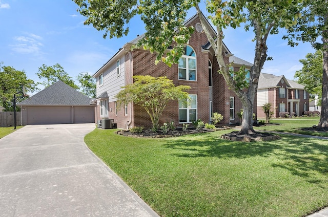 view of front of house featuring an outbuilding, a detached garage, a front lawn, brick siding, and central AC unit