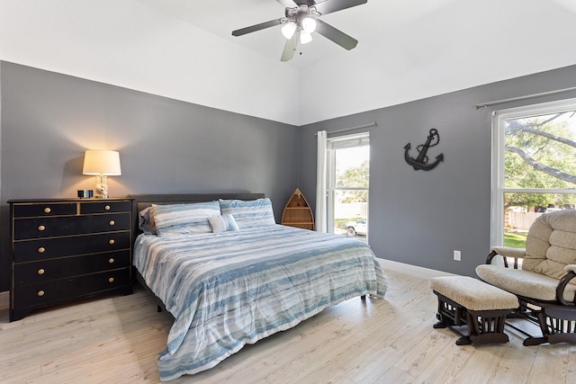 bedroom featuring light wood-style flooring, multiple windows, and baseboards