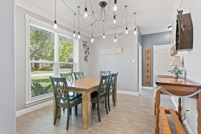 dining room with crown molding, light wood-style floors, visible vents, a chandelier, and baseboards