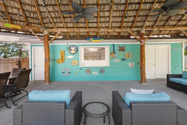 view of patio / terrace with an outdoor living space, ceiling fan, and fence