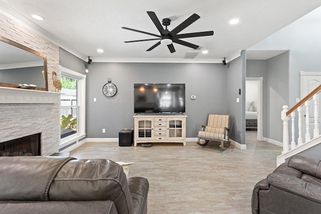 living area featuring a fireplace, a ceiling fan, crown molding, stairs, and visible vents