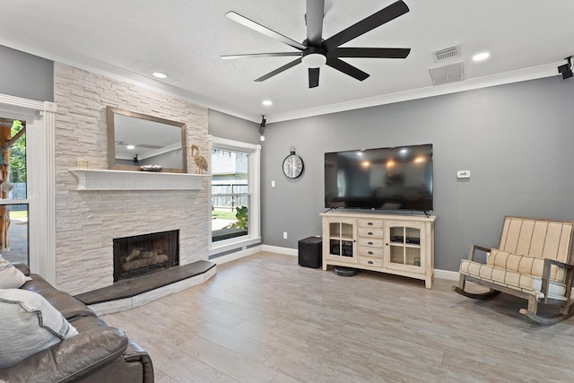 living room with wood finished floors, a ceiling fan, visible vents, and a wealth of natural light