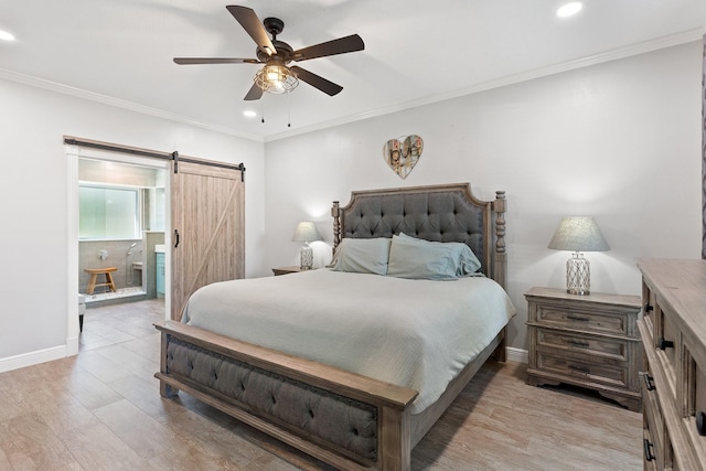 bedroom with light wood-style floors, recessed lighting, and a barn door