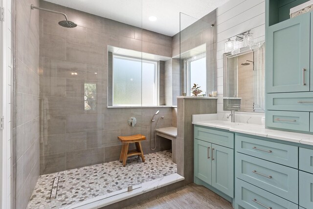 full bath featuring vanity, walk in shower, and wood finished floors