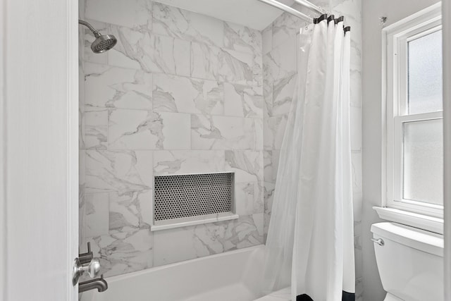 bathroom featuring shower / tub combo and toilet