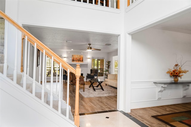 foyer entrance featuring stairway, a ceiling fan, and wood finished floors