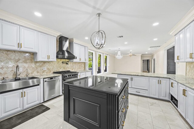 509 Joan Of Arc Dr, Hempstead, TX 77445 - kitchen featuring wall chimney range hood, appliances with stainless steel finishes, a sink, a chandelier, and tasteful backsplash