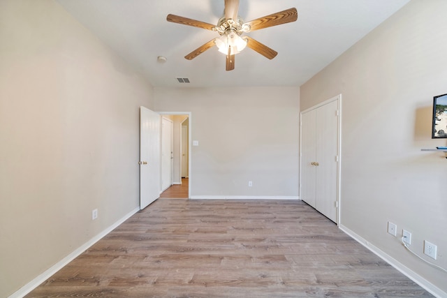 unfurnished bedroom featuring wood finished floors, visible vents, baseboards, and ceiling fan