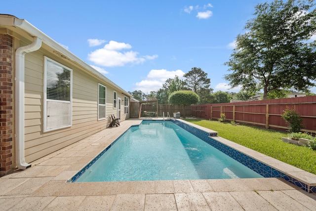 view of swimming pool with a lawn, a fenced backyard, a fenced in pool, and a patio