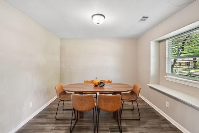 dining area featuring visible vents, baseboards, and dark wood finished floors