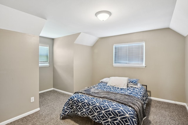 carpeted bedroom with baseboards and lofted ceiling