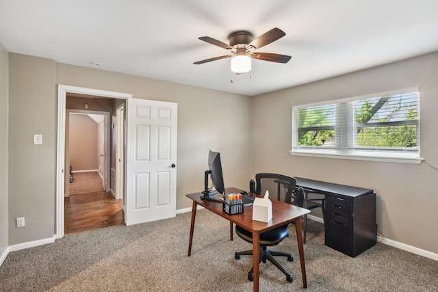 carpeted home office featuring a ceiling fan and baseboards