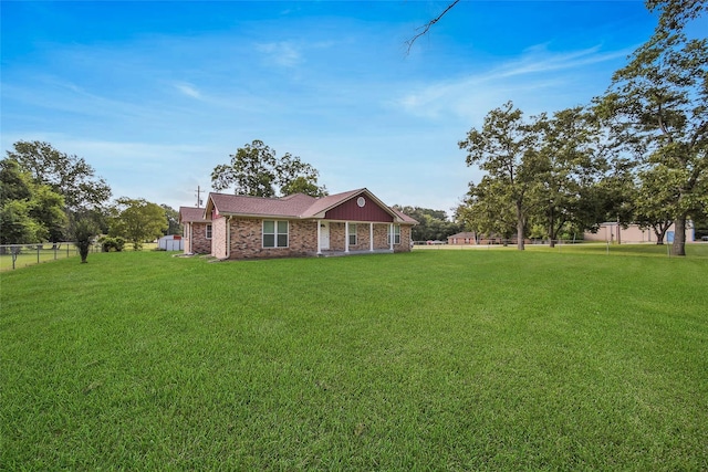 2201 Badger Ln, Huntsville, TX 77320 - view of front facade featuring brick siding, a front lawn, and fence
