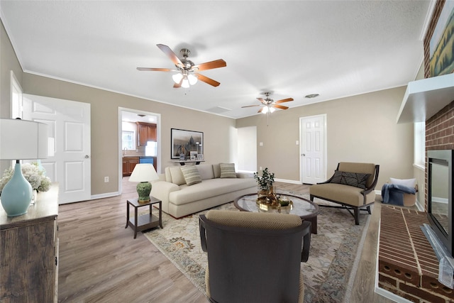 2201 Badger Ln, Huntsville, TX 77320 - living area with a brick fireplace, baseboards, wood finished floors, and ceiling fan