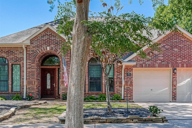 view of front of property with a garage, brick siding, a shingled roof, and driveway
