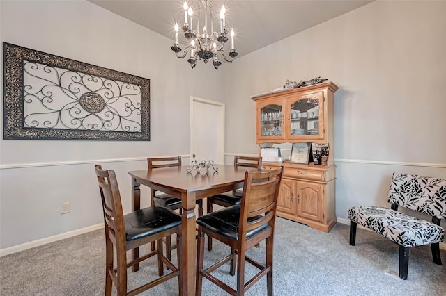 dining room with a chandelier, baseboards, and light carpet