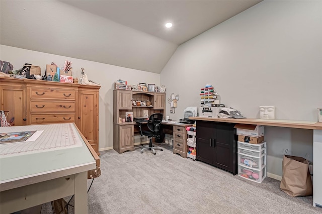 office space featuring baseboards, lofted ceiling, and light colored carpet
