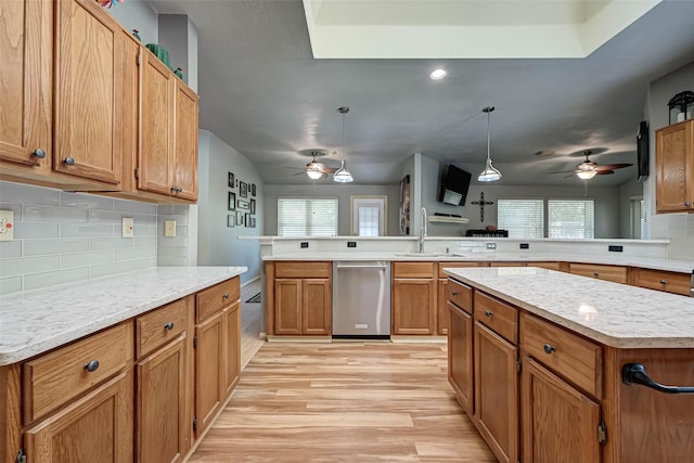 kitchen with ceiling fan, a peninsula, dishwasher, and a sink