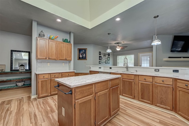 kitchen with light wood finished floors, a sink, and light countertops