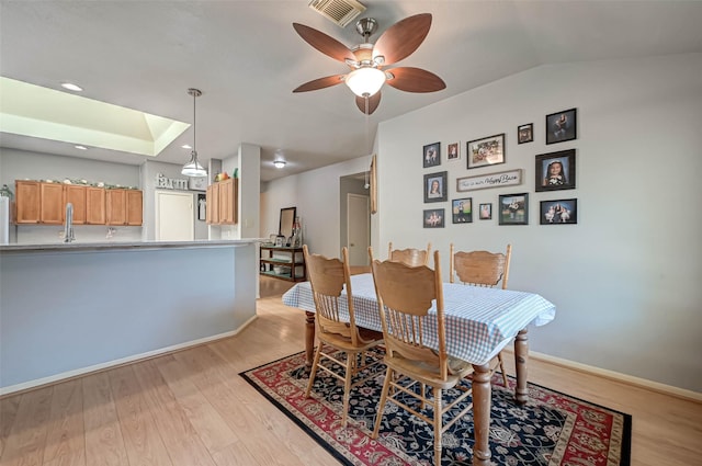 dining room featuring ceiling fan, visible vents, light wood-type flooring, and baseboards