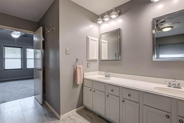 full bath featuring double vanity, ceiling fan, and a sink