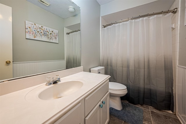 full bathroom featuring a shower with curtain, a wainscoted wall, toilet, vanity, and visible vents