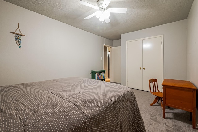 carpeted bedroom featuring a textured ceiling, ceiling fan, and a closet