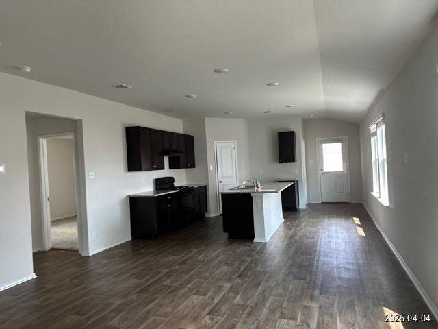 6710 Greensleeves, San Antonio, TX 78252 - kitchen featuring baseboards, an island with sink, dark wood-style floors, light countertops, and electric range