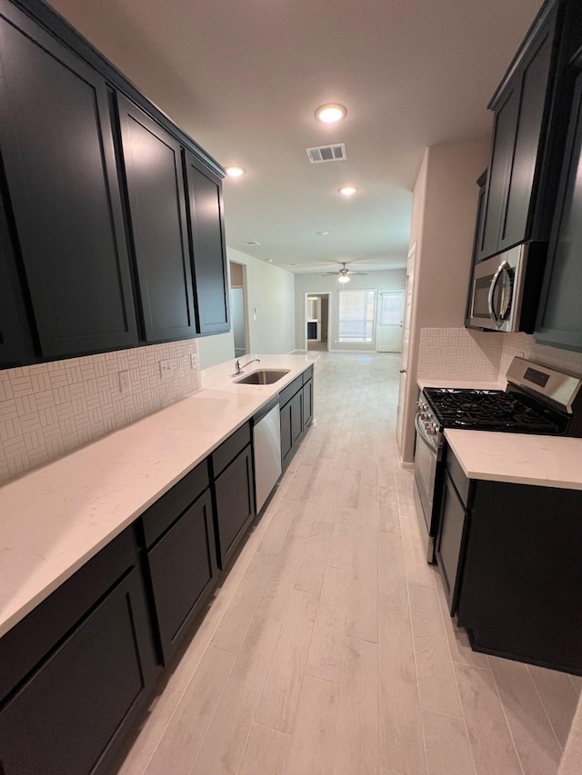 526 Emerald Thicket Ln, Huffman, TX 77336 - kitchen featuring stainless steel appliances, ceiling fan, dark cabinetry, backsplash, and recessed lighting