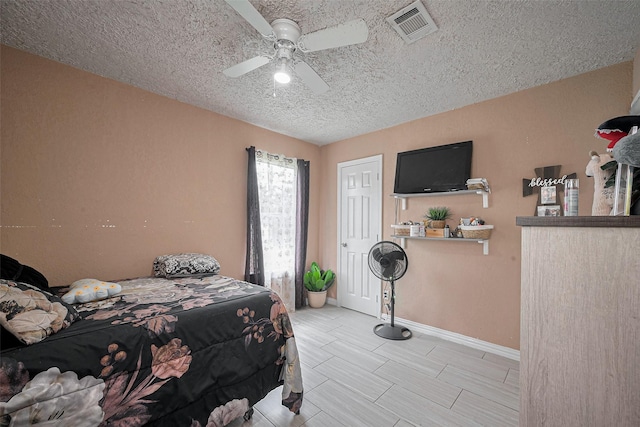 9034 Talton St, Houston, TX 77078 - bedroom with a textured ceiling, baseboards, a ceiling fan, and visible vents