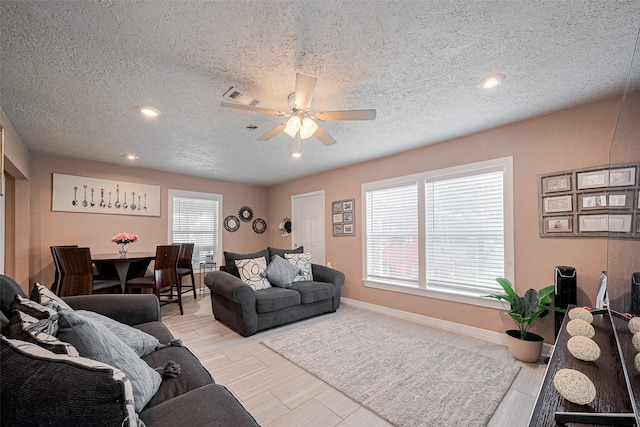 9034 Talton St, Houston, TX 77078 - living room with baseboards, visible vents, a textured ceiling, and a ceiling fan