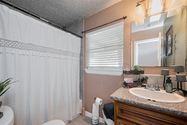 9034 Talton St, Houston, TX 77078 - bathroom with toilet, vanity, a textured wall, and a textured ceiling