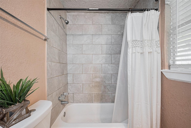 9034 Talton St, Houston, TX 77078 - full bathroom with a textured wall, shower / bath combo with shower curtain, and toilet
