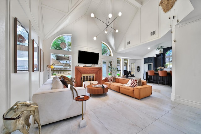 living area with visible vents, a wealth of natural light, and high vaulted ceiling