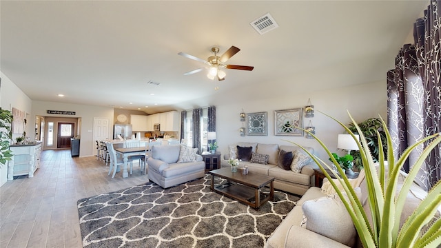 living area with visible vents, light wood-type flooring, a ceiling fan, and recessed lighting