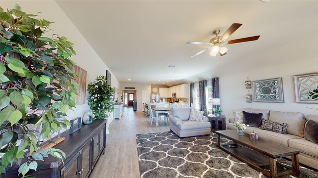 living area featuring ceiling fan, recessed lighting, plenty of natural light, and light wood-style floors