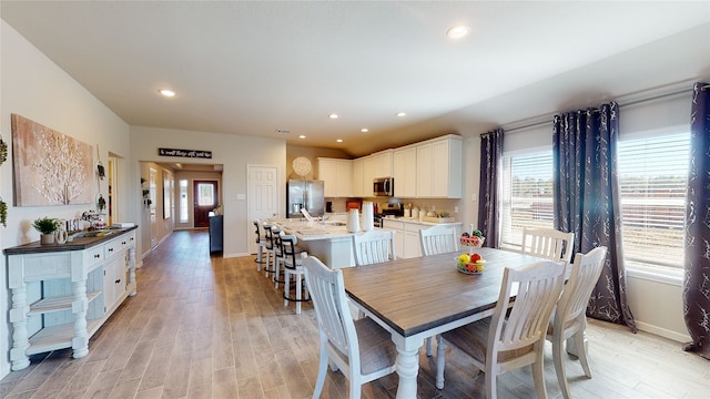 dining room with light wood-style flooring, recessed lighting, plenty of natural light, and baseboards