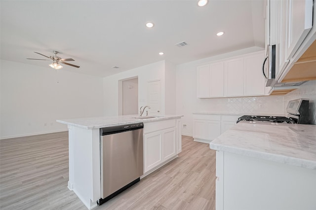 22607 Rising Rosehill Ln, Tomball, TX 77377 - kitchen with appliances with stainless steel finishes, a sink, light wood finished floors, a ceiling fan, and light stone counters