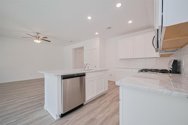 22607 Rising Rosehill Ln, Tomball, TX 77377 - kitchen with appliances with stainless steel finishes, a ceiling fan, light wood finished floors, light stone countertops, and decorative backsplash