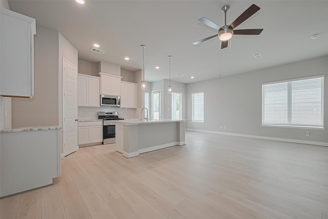 8915 Grovner Pl, Houston, TX 77055 - kitchen with appliances with stainless steel finishes, a ceiling fan, light countertops, light wood-style floors, and recessed lighting