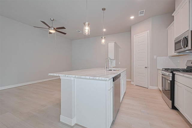 8915 Grovner Pl, Houston, TX 77055 - kitchen with stainless steel appliances, a sink, ceiling fan, tasteful backsplash, and light wood-type flooring