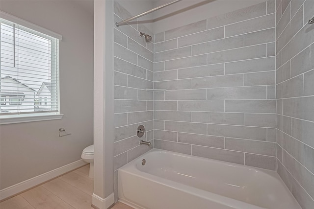 8915 Grovner Pl, Houston, TX 77055 - bathroom with toilet, baseboards, shower / washtub combination, and wood finished floors