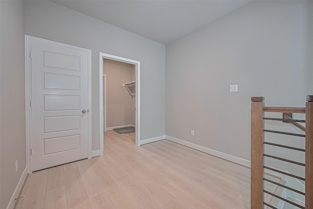 8915 Grovner Pl, Houston, TX 77055 - unfurnished bedroom featuring light wood-type flooring, baseboards, a walk in closet, and a closet