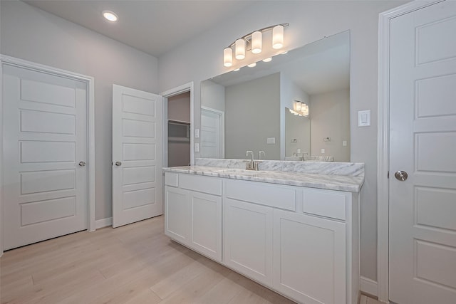 8915 Grovner Pl, Houston, TX 77055 - bathroom with vanity, wood finished floors, recessed lighting, and baseboards