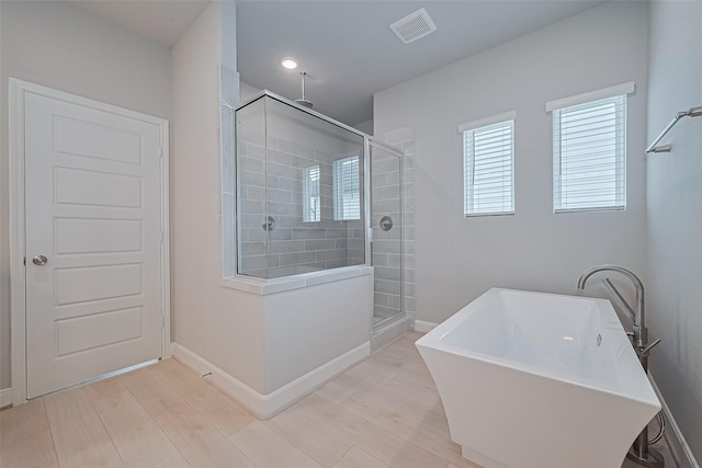 8915 Grovner Pl, Houston, TX 77055 - bathroom with a shower stall, a soaking tub, wood finished floors, and baseboards