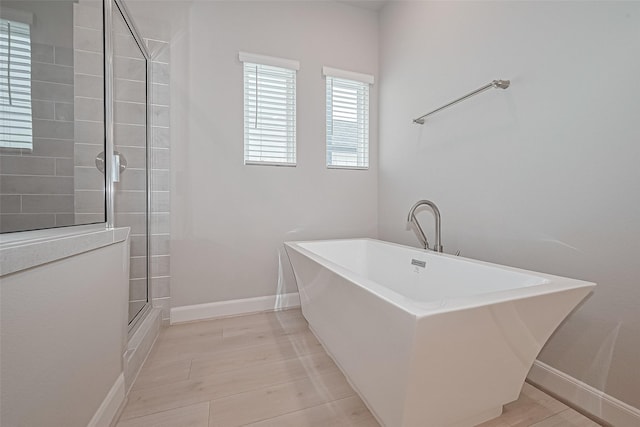 8915 Grovner Pl, Houston, TX 77055 - bathroom featuring a soaking tub, tiled shower, and baseboards