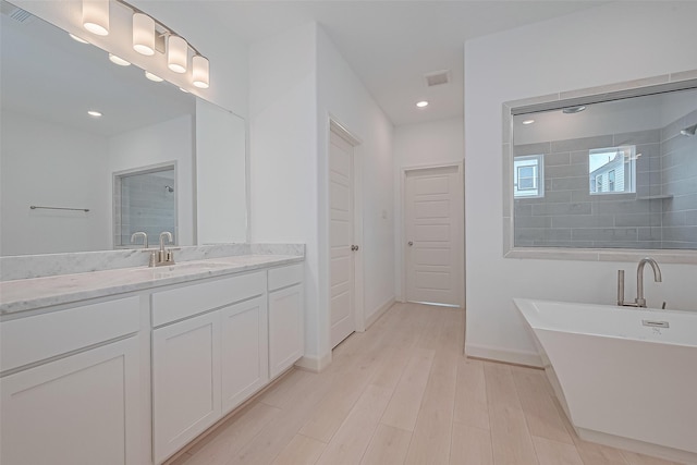 1609 Regents Gate, Houston, TX 77055 - bathroom featuring vanity, a freestanding tub, a tile shower, wood finished floors, and recessed lighting