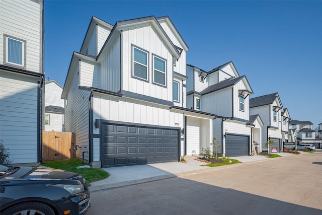 view of front of home with concrete driveway, board and batten siding, a garage, and a residential view